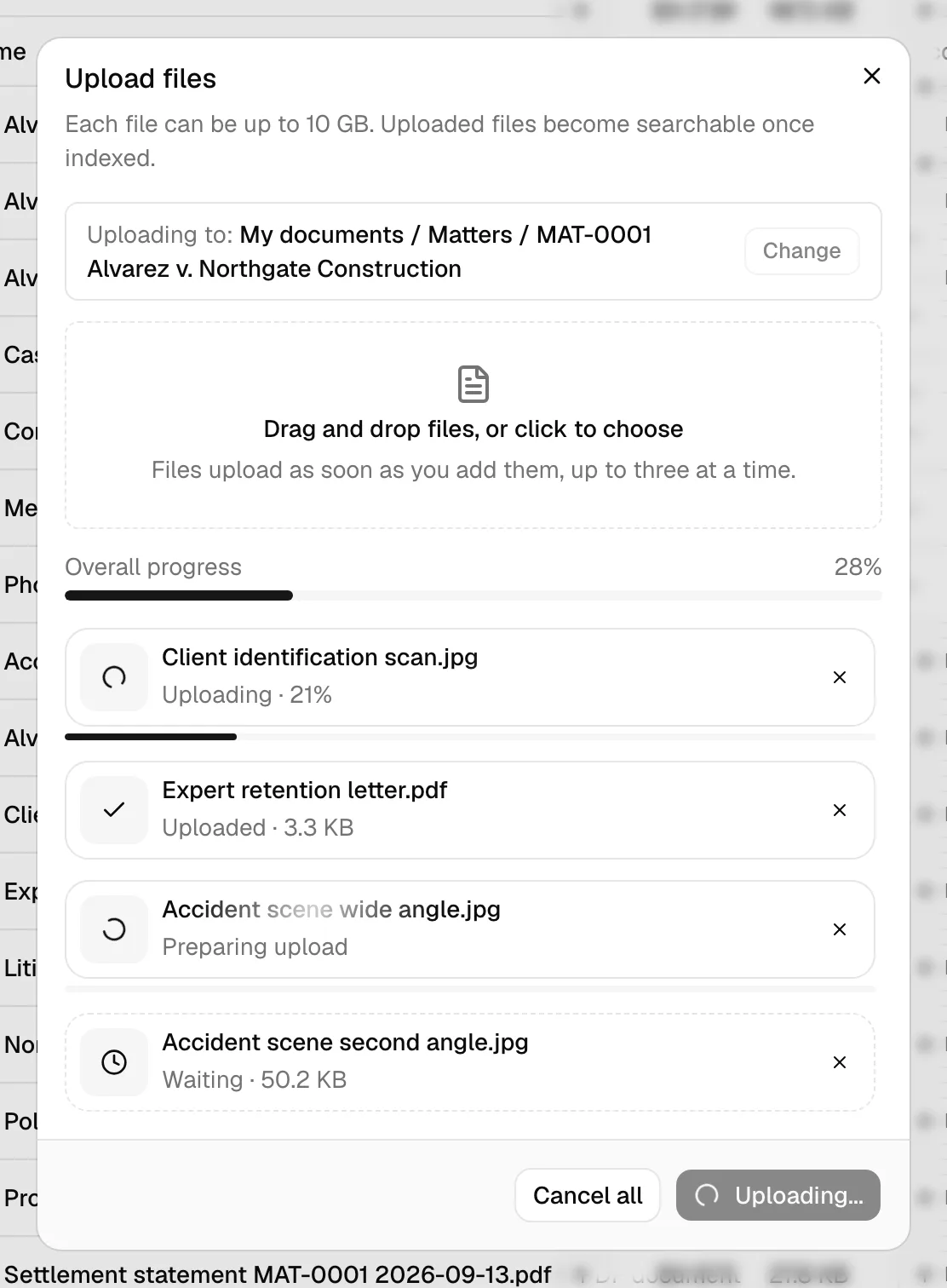 The Upload files dialog mid-upload, showing the drop zone and a list of file rows: one Uploaded with a check mark, one Uploading with its percentage, and one